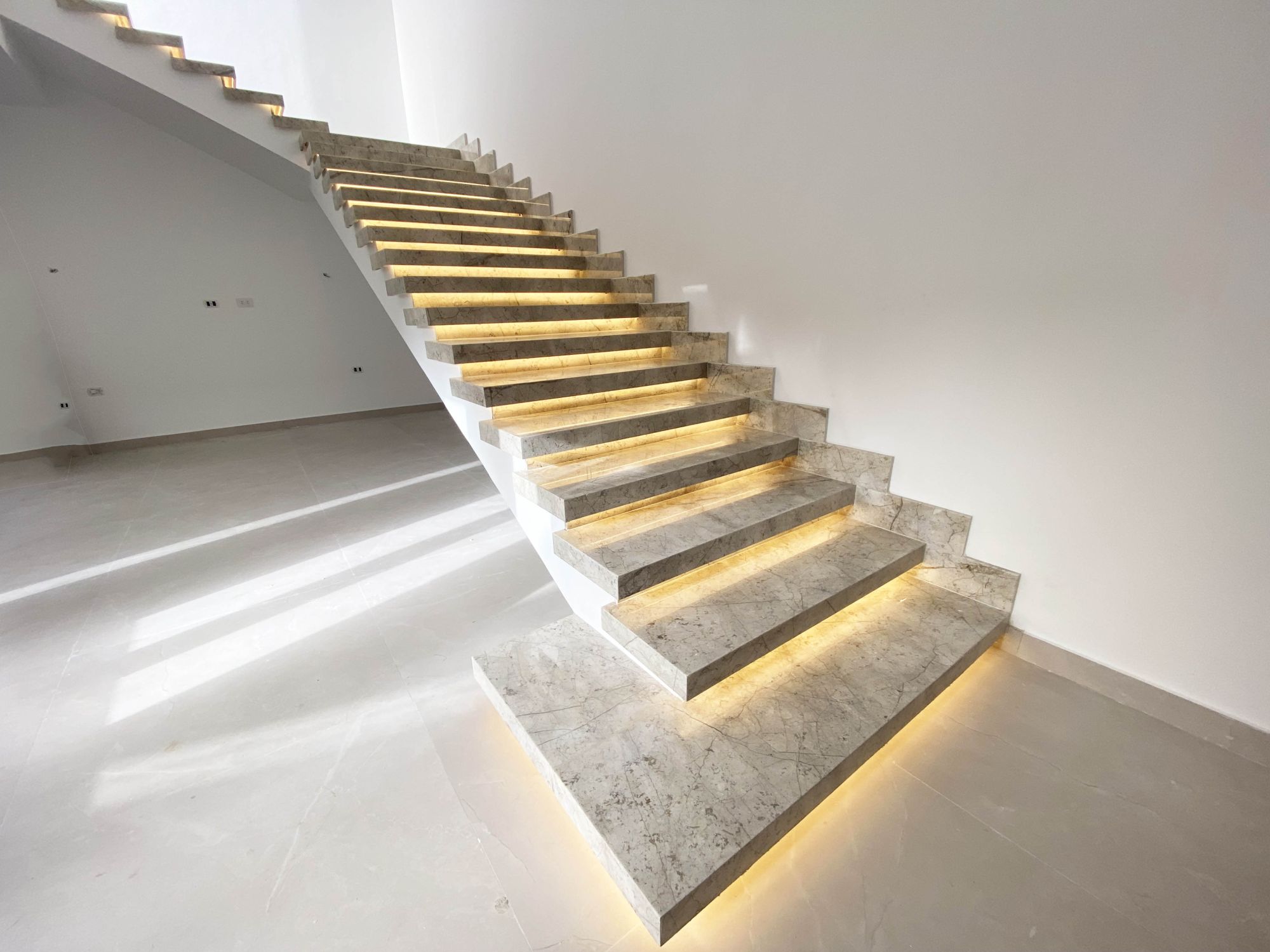 Execution of a staircase made of premium Biat Grey marble, with thickness and the addition of a LED profile lighting groove.